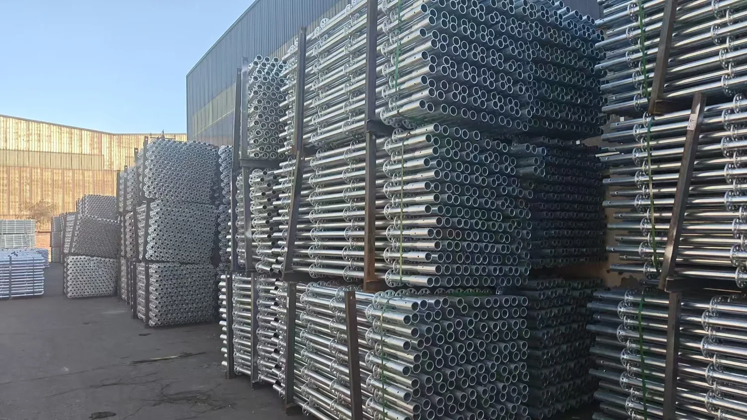 Worker checking steel straps and bundle condition before Ringlock scaffolding loading